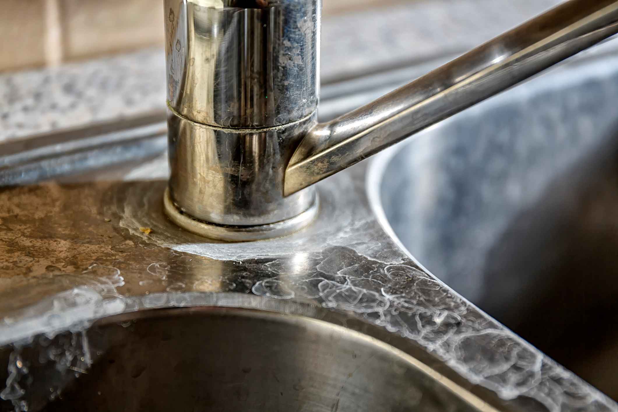 hard water spots on a kitchen sink faucet