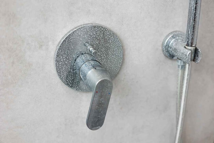 hard-water-3 - Affordable Plumbing Shower faucet handle with calcium deposits on it. Plaque and mineral deposits from hard water on shower faucet handle.